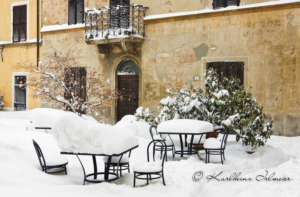 Snow covered tables and chairs in Pienza, Tuscany